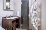 This modern bathroom boasts a sleek, dark wood vanity with a built-in sink and ample storage.