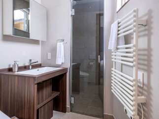 This modern bathroom boasts a sleek, dark wood vanity with a built-in sink and ample storage.