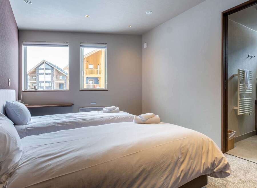 This cozy bedroom features two twin beds with crisp white linens, perfect for a relaxing stay.