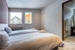 This cozy bedroom features two twin beds with crisp white linens, perfect for a relaxing stay.