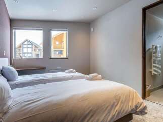 This cozy bedroom features two twin beds with crisp white linens, perfect for a relaxing stay.