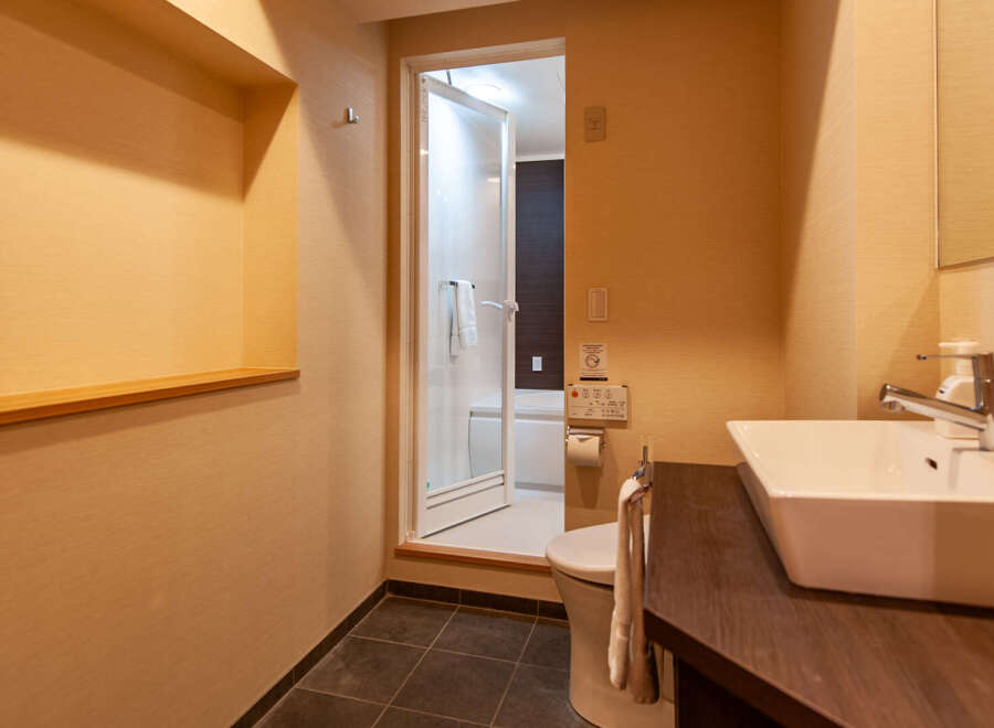 This modern hotel bathroom boasts a sleek, contemporary design with a spacious sink and vanity.