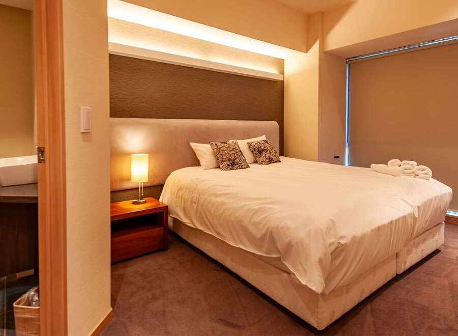 This cozy bedroom features a comfortable double bed with crisp white linens, complemented by a stylish headboard and soft pillows.