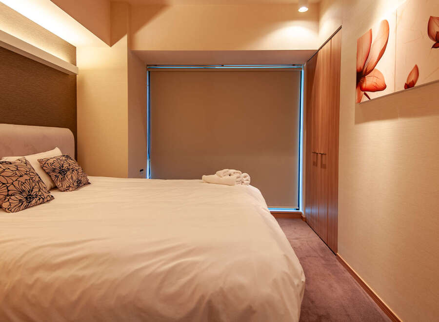 This modern hotel room boasts a comfortable king-size bed with plush pillows and crisp white linens.