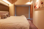 This modern hotel room boasts a comfortable king-size bed with plush pillows and crisp white linens.