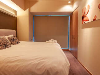 This modern hotel room boasts a comfortable king-size bed with plush pillows and crisp white linens.