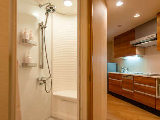 This modern apartment boasts a compact yet functional kitchen with wood cabinets, complete with a microwave and dishwasher.