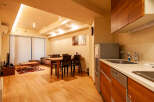 This modern apartment boasts an open-plan living area with hardwood floors, a comfortable sofa, and a dining table for four.