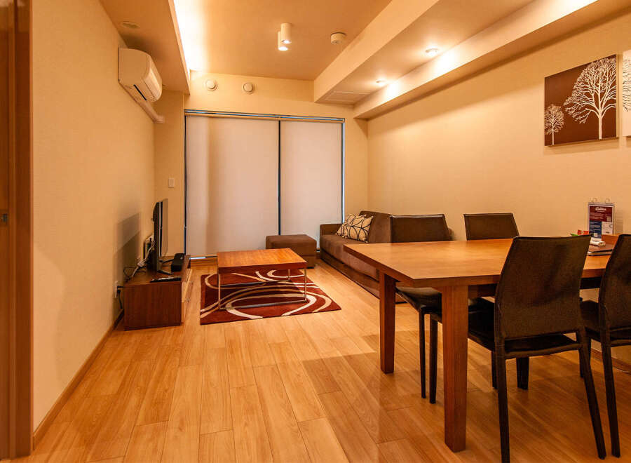 This modern apartment boasts an open-plan living and dining area with hardwood floors, creating a spacious and inviting atmosphere.