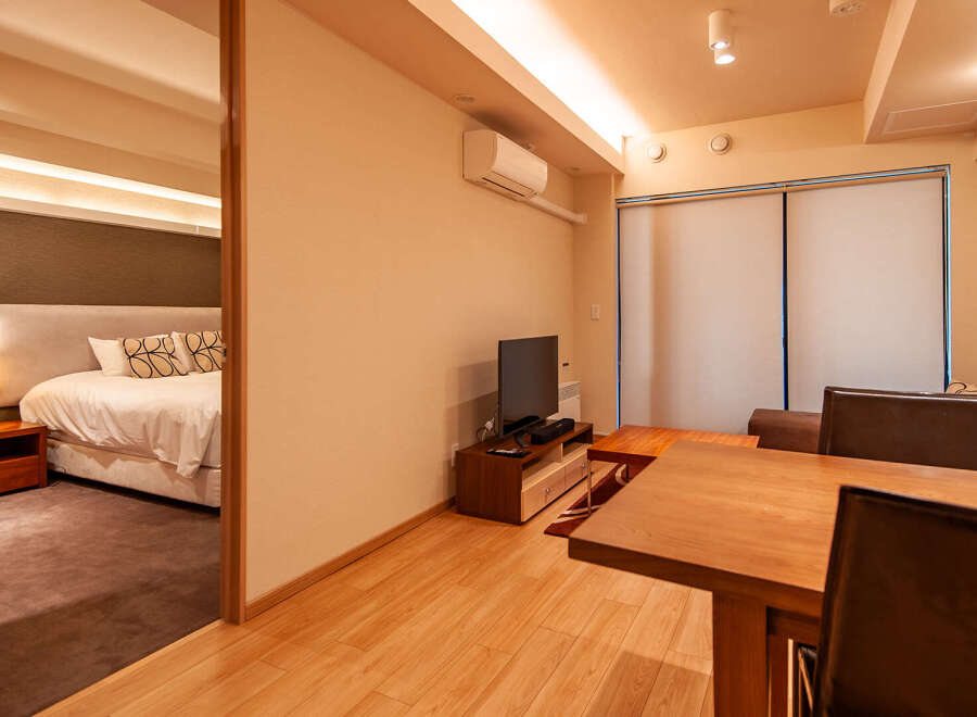 This modern apartment boasts an open-plan living area with a dining table and comfortable seating, perfect for relaxing after a day of exploring.