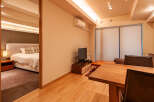 This modern apartment boasts an open-plan living area with a dining table and comfortable seating, perfect for relaxing after a day of exploring.