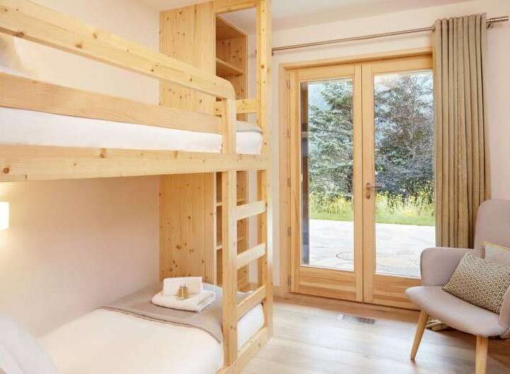 This cozy bedroom features a custom-built bunk bed, perfect for accommodating guests or family.
