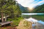 Escape to a serene lakeside retreat surrounded by lush greenery and majestic mountains.