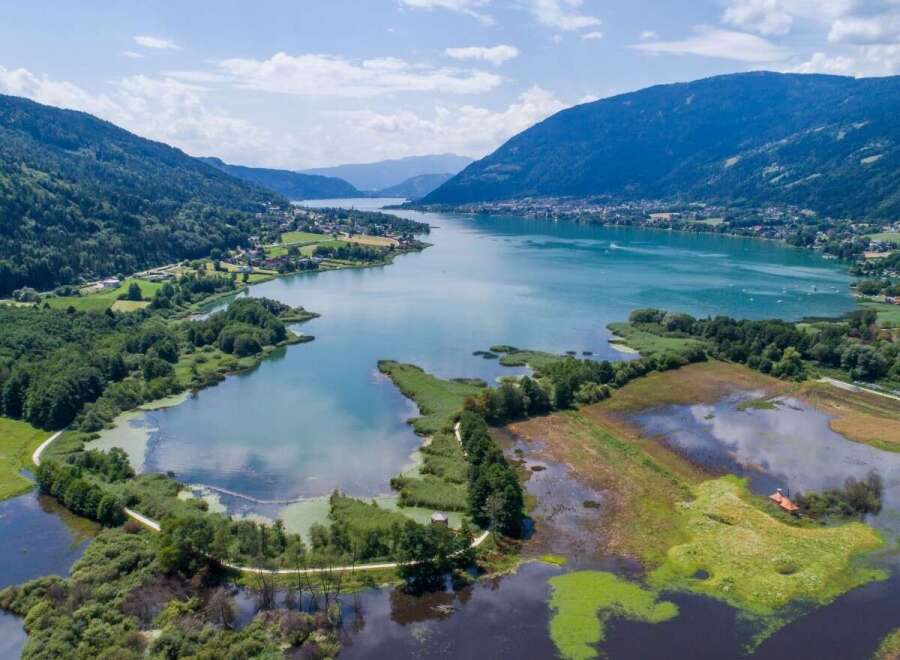 Experience the breathtaking beauty of this stunning lake surrounded by lush greenery and majestic mountains.