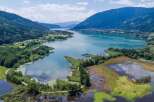 Experience the breathtaking beauty of this stunning lake surrounded by lush greenery and majestic mountains.