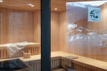 This luxurious sauna boasts a stunning wooden interior, complete with plush towels and a wooden bucket.