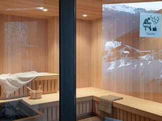 This luxurious sauna boasts a stunning wooden interior, complete with plush towels and a wooden bucket.