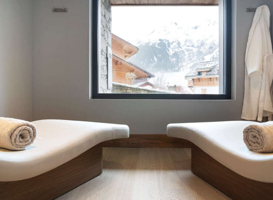 Relax and rejuvenate in our luxurious spa, featuring comfortable chaise lounges with plush towels and stunning mountain views.