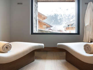 Relax and rejuvenate in our luxurious spa, featuring comfortable chaise lounges with plush towels and stunning mountain views.