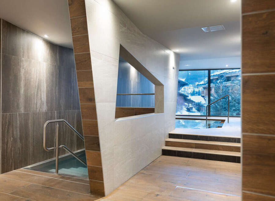 This luxurious spa boasts a stunning indoor pool with floor-to-ceiling windows offering breathtaking mountain views.