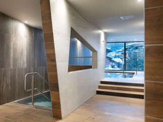 This luxurious spa boasts a stunning indoor pool with floor-to-ceiling windows offering breathtaking mountain views.