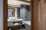 This luxurious bathroom boasts a modern design with sleek gray tiles and a spacious walk-in shower.