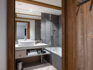 This luxurious bathroom boasts a modern design with sleek gray tiles and a spacious walk-in shower.