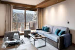 This stunning apartment boasts breathtaking views of snow-capped mountains, accessible through large sliding doors leading to a private balcony.