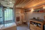 Cozy chalet bathroom with wooden features, including a glass block window, heated towel rack, and stylish vanity with storage.
