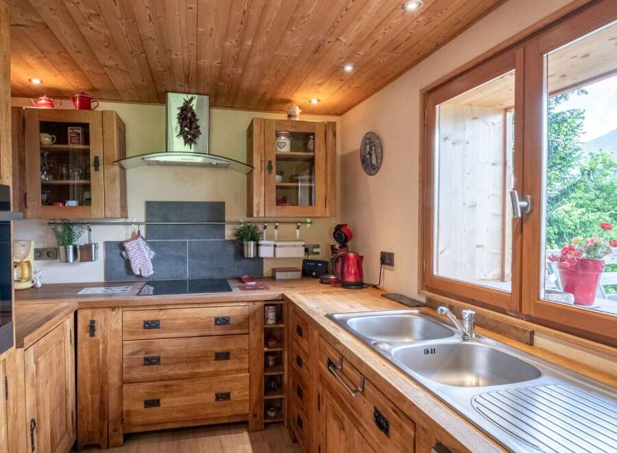 Rustic wooden kitchen with modern appliances and stunning mountain views.