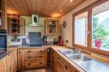 Rustic wooden kitchen with modern appliances and stunning mountain views.
