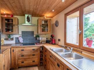 Rustic wooden kitchen with modern appliances and stunning mountain views.