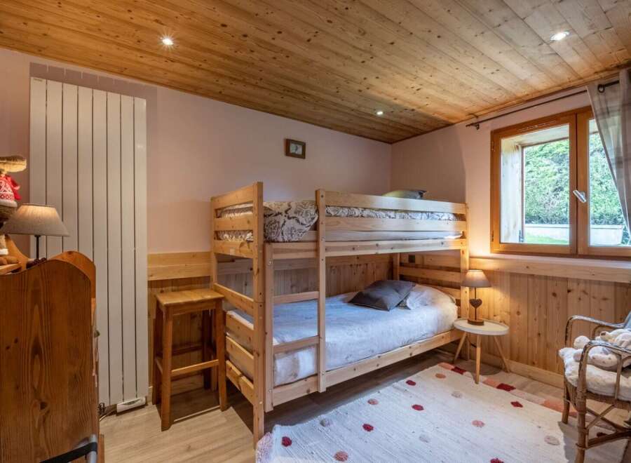 Cozy chalet bedroom featuring a wooden bunk bed, perfect for families.