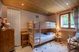 Cozy chalet bedroom featuring a wooden bunk bed, perfect for families.