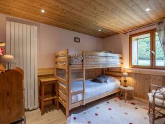 Cozy chalet bedroom featuring a wooden bunk bed, perfect for families.