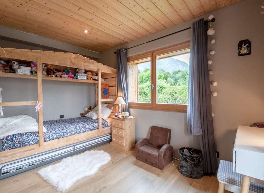 Charming wooden bunk bed in a child's bedroom with a view.
