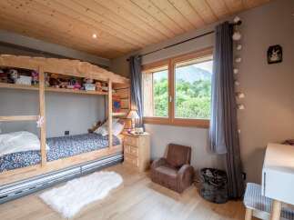 Charming wooden bunk bed in a child's bedroom with a view.