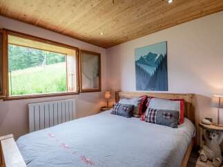 Cozy bedroom with wooden accents and mountain views.