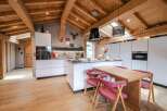This stunning chalet boasts a spacious, open-plan kitchen with modern white cabinetry and high-end appliances.