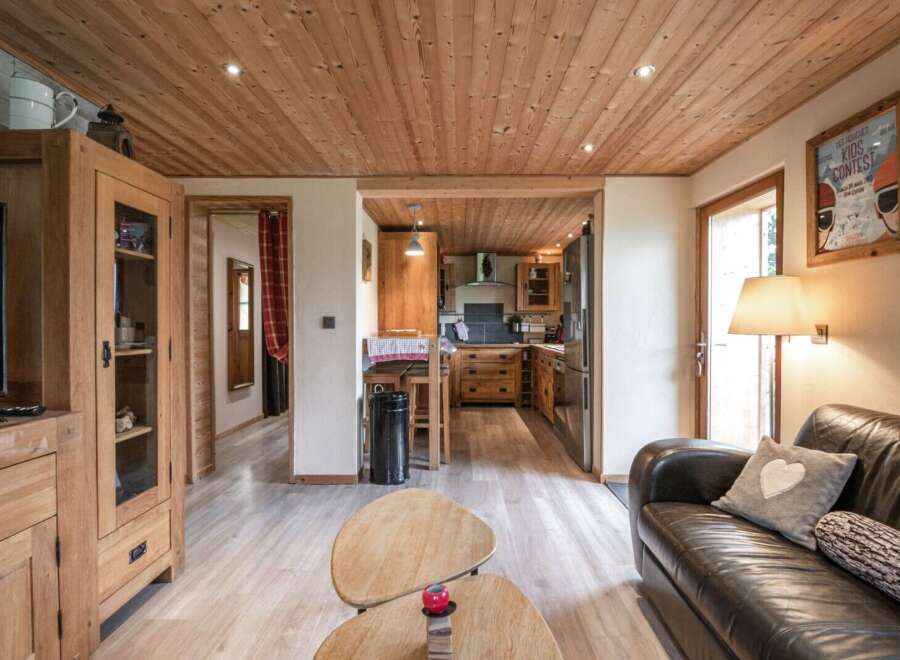 Cozy chalet living room with wooden floors and a leather sofa.