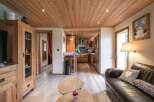 Cozy chalet living room with wooden floors and a leather sofa.
