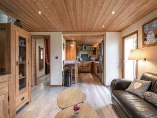 Cozy chalet living room with wooden floors and a leather sofa.