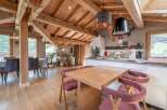 This stunning chalet boasts a spacious open-plan living area with exposed wooden beams and large windows offering breathtaking views.