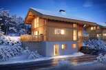Experience the charm of a cozy wooden chalet nestled in a snowy landscape.