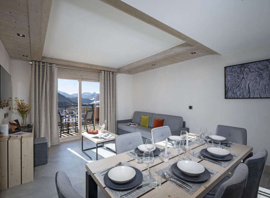 This stunning apartment boasts a spacious open-plan living area with floor-to-ceiling windows offering breathtaking mountain views.