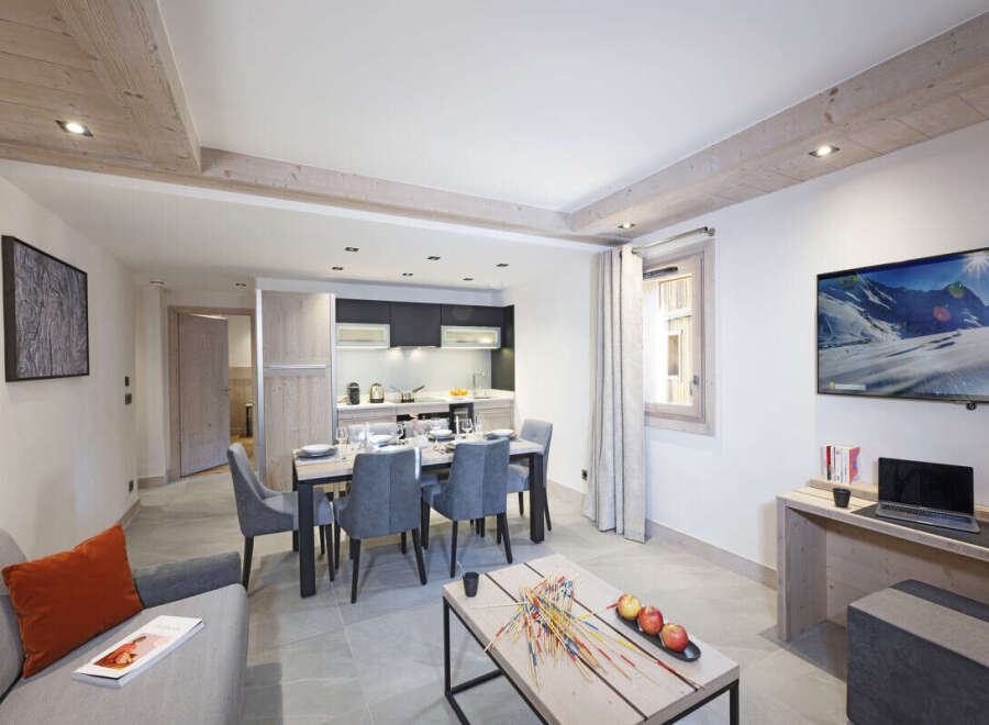 This stunning apartment boasts an open-plan living area with a modern kitchen, dining table, and comfortable seating.