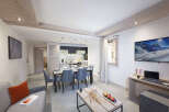 This stunning apartment boasts an open-plan living area with a modern kitchen, dining table, and comfortable seating.