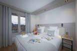 Cozy bedroom with twin beds, featuring a rustic wooden headboard and gray bedding.