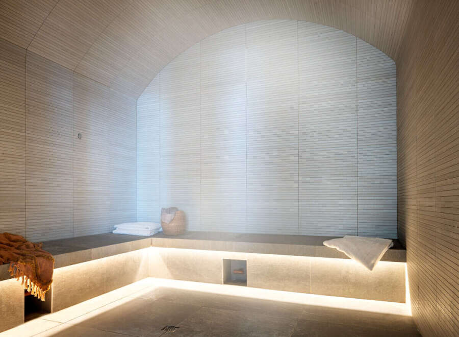 Indulge in tranquility within this exquisitely designed steam room, showcasing a calming neutral palette and sleek, modern finishes.