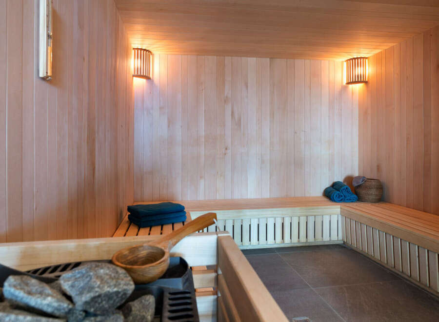 Indulge in tranquility within this exquisite sauna, meticulously crafted with premium wood paneling and featuring ambient lighting.